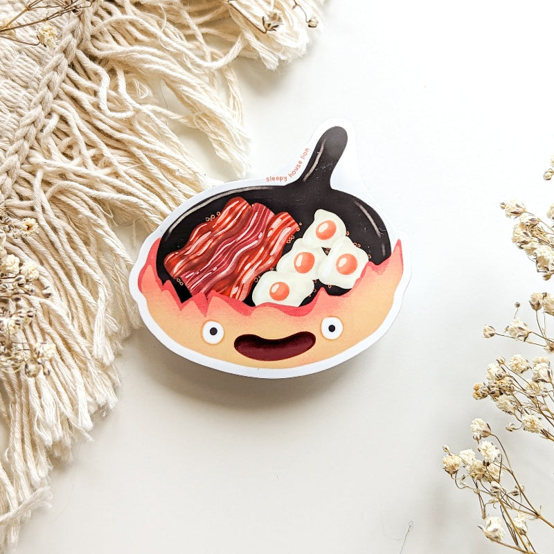 frying pan with a smile cooking bacon and eggs