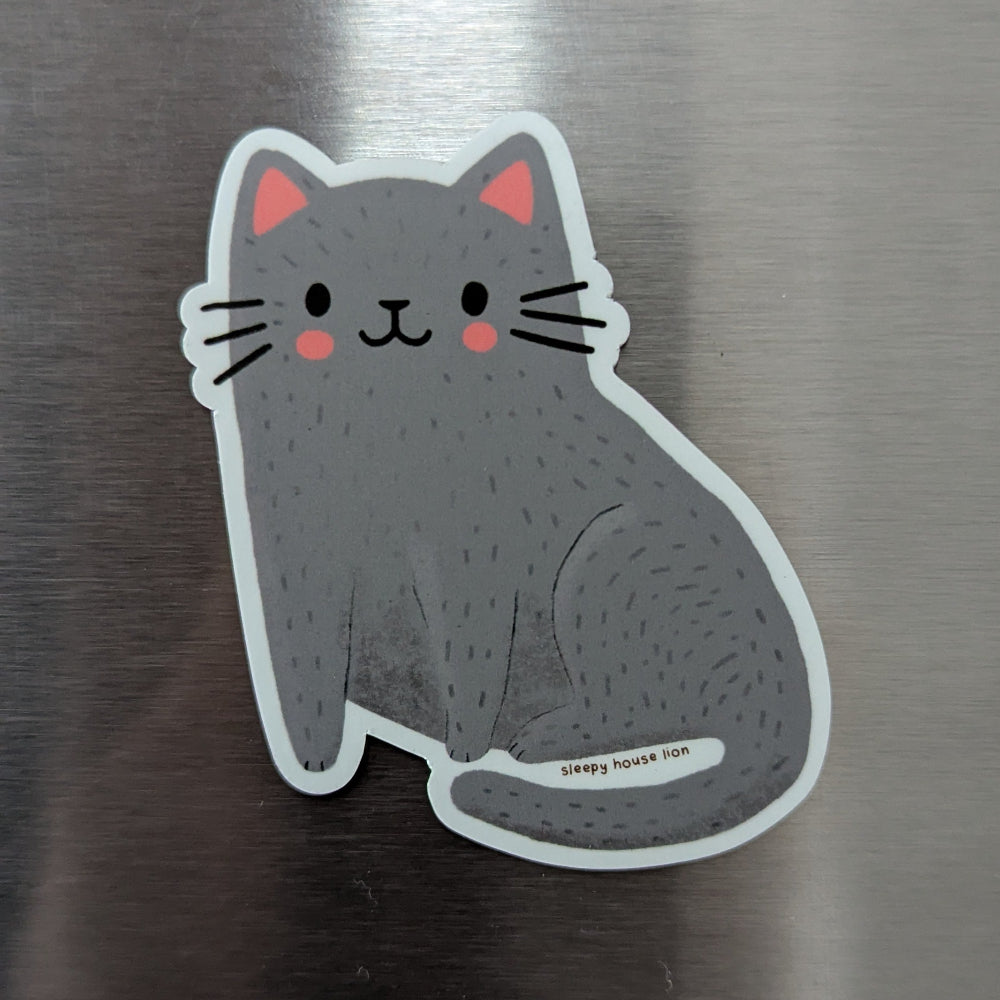 Fridge magnet shaped like a cat on a metallic surface