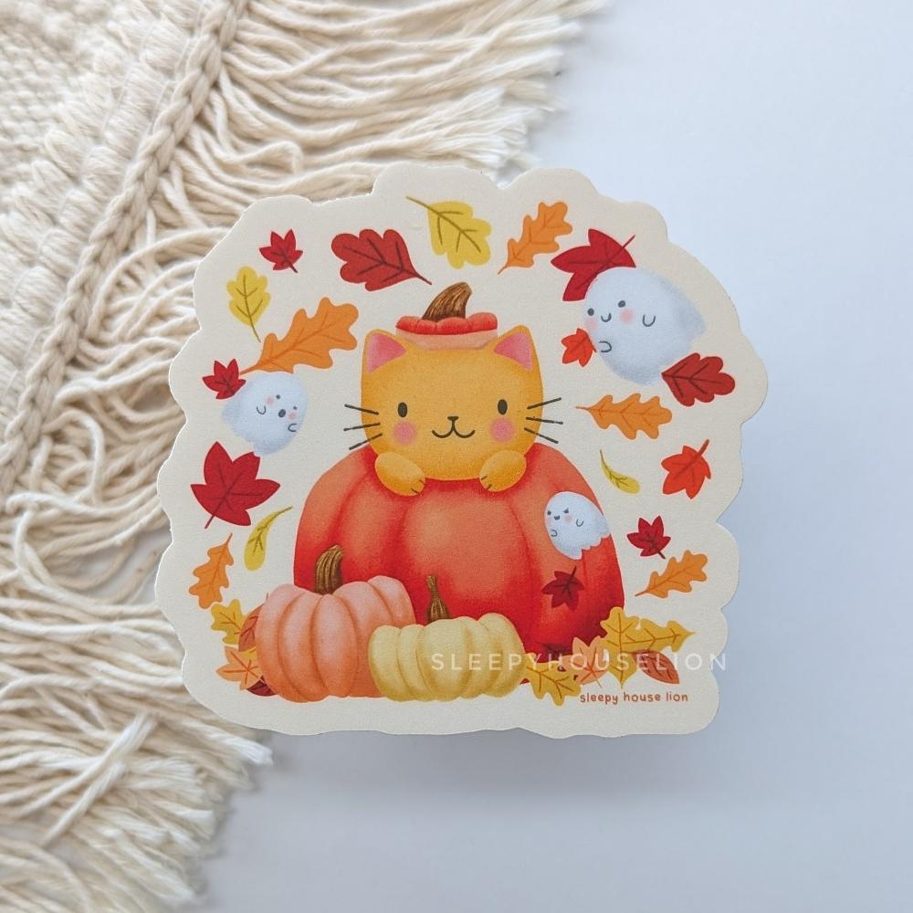 cat in pumpkin with ghosts and leaves falling