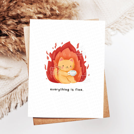 Card with a cat illustration and 'everything is fine' text on a textured surface