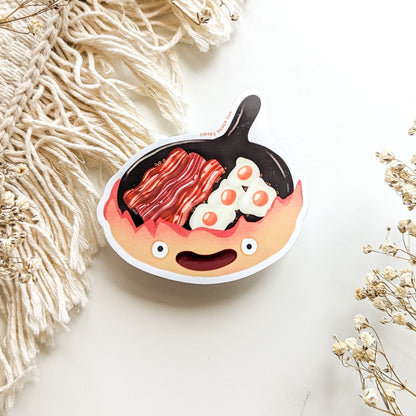 frying pan with a smile cooking bacon and eggs