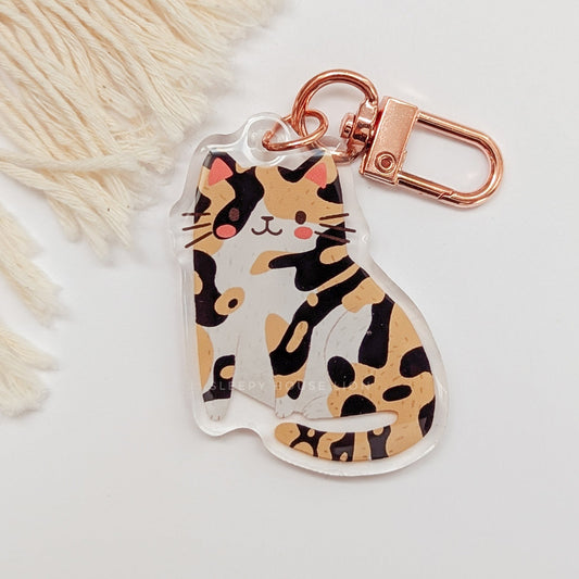 Cat-shaped keychain with a rose gold clasp on a light background