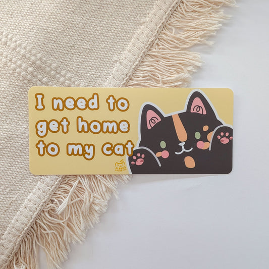 Card with a cat illustration and text 'I need to get home to my cat' on a textured fabric background.
