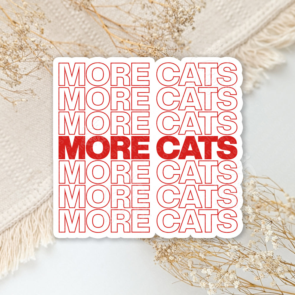 Two stickers with 'MORE CATS  MORE CATS MORE CATS' text on a neutral background