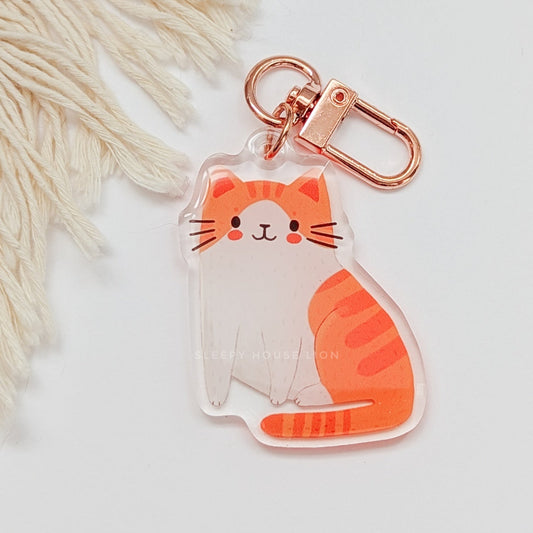 Cat-shaped keychain with rose gold clip on a light background