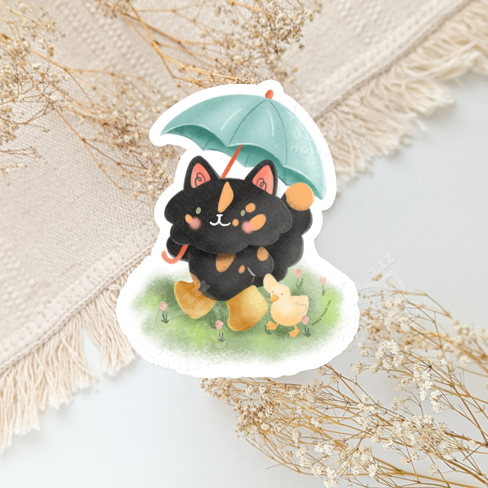 Sticker of a tortie cat with an umbrella holding a duck
