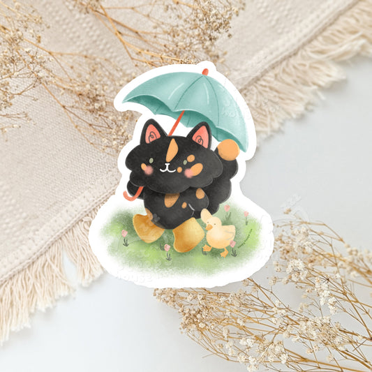 Sticker of a tortie cat with an umbrella holding a duck
