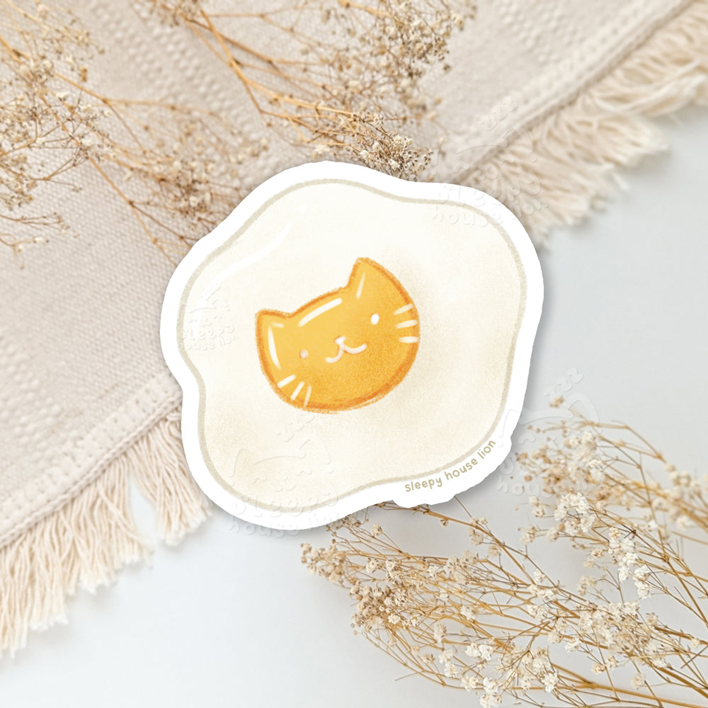 Cute vinyl sticker featuring a sunny side up cat as a yolkl